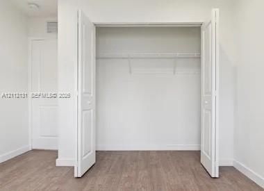 Reach-in closet featuring white bi-fold doors, white interior walls, and built-in wire shelving