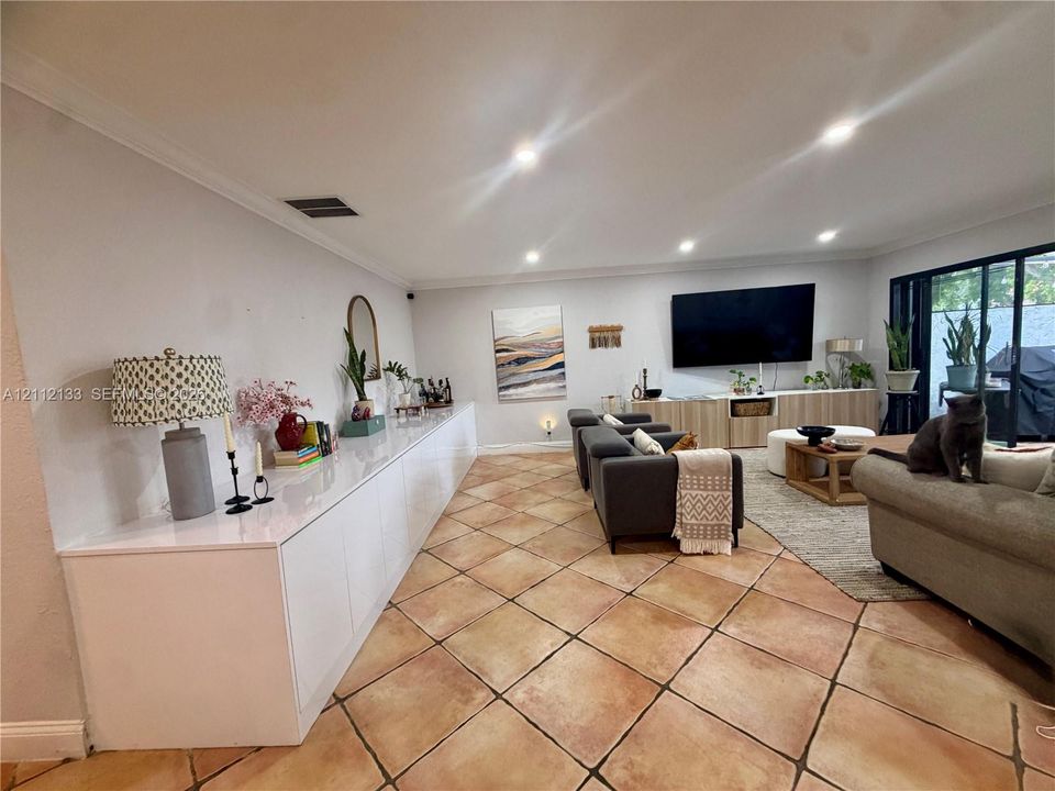 Kitchen featuring dark-finish cabinetry, a wrap-around stone-surface breakfast bar, recessed lighting, and tile flooring