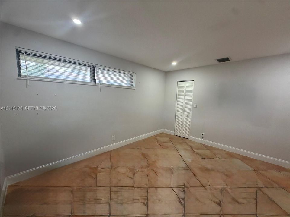 Interior space featuring neutral wall paint, tile flooring, two horizontal sliding windows, and recessed lighting