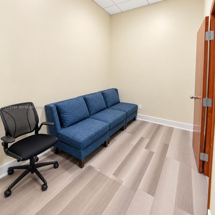 Room featuring wood-finish flooring, neutral wall paint, and a solid-core wood door