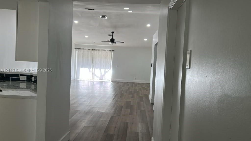 Interior featuring wood-finish flooring, recessed lighting, a ceiling fan, and sliding glass doors