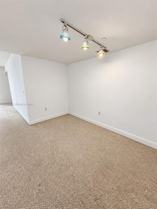 Neutral wall-to-wall carpeting and adjustable three-light track fixture