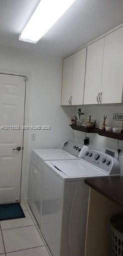 Utility room featuring white shaker-style wall cabinetry, horizontal wall-mounted shelving, tile flooring, and a flush-mount overhead light fixture