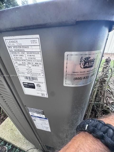 Exterior Lennox heat pump unit featuring a gray metal casing and professional service labeling