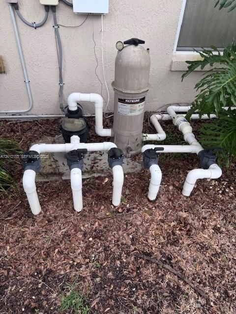 Pool filtration system featuring a Hayward cartridge filter, circulation pump, and multi-port valve plumbing configuration