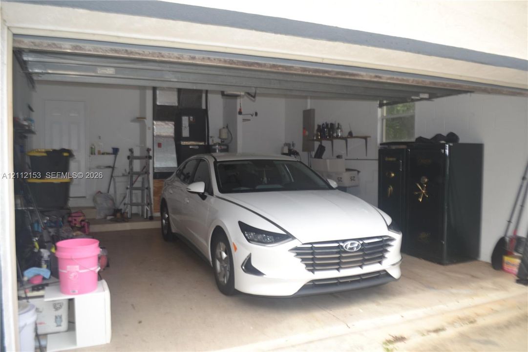 Attached garage featuring concrete flooring, an overhead sectional door, and an exterior entry door