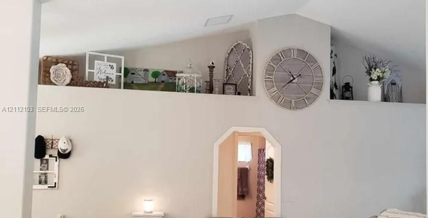 Vaulted ceilings featuring recessed display shelving, complemented by a segmented archway
