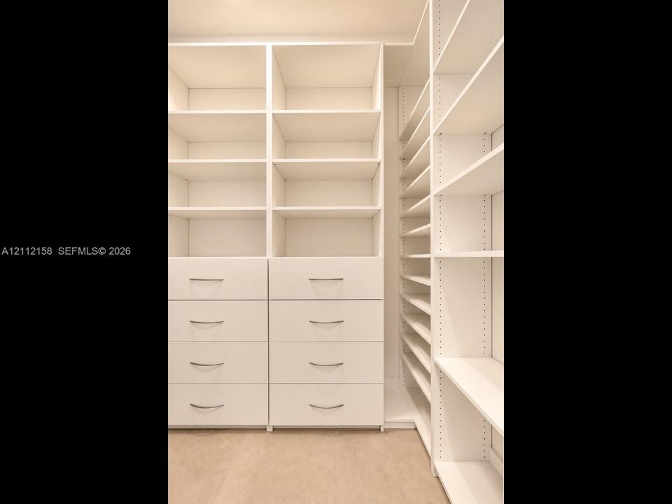 Custom floor-to-ceiling built-in storage with integrated drawers and polished hardware — a place for everything