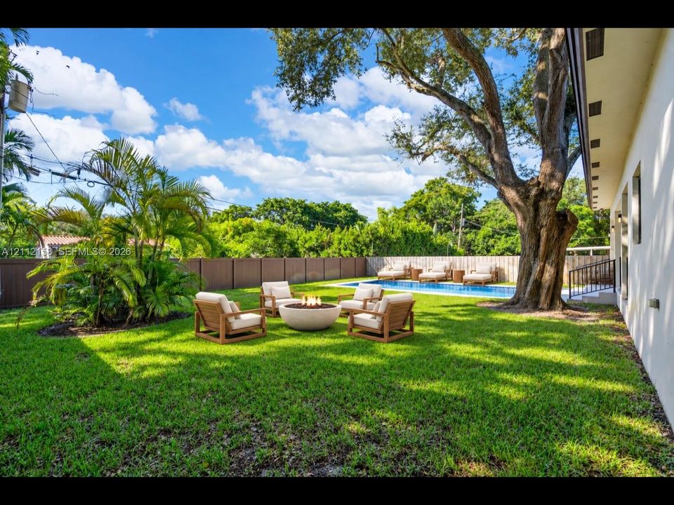 (Digitally staged) Enjoy evenings by the stone fire pit beside the pool, surrounded by mature trees and privacy fencing