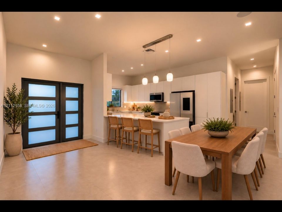 (Digitally staged) Open dining and kitchen area with stone countertops, recessed lighting, and a frosted-glass door that adds style and privacy