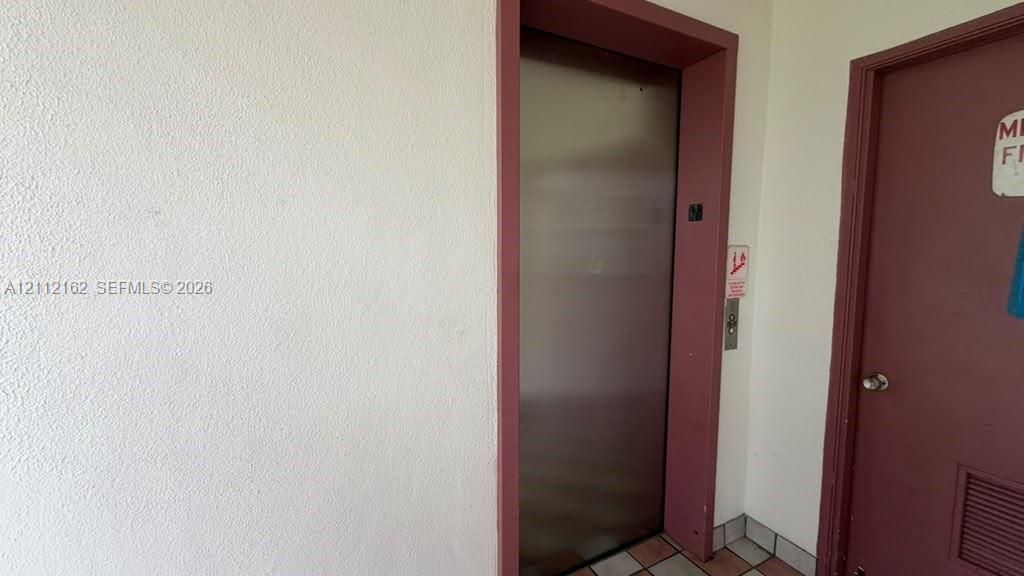 Stainless steel elevator doors featuring a metallic finish and a classic push-button control panel