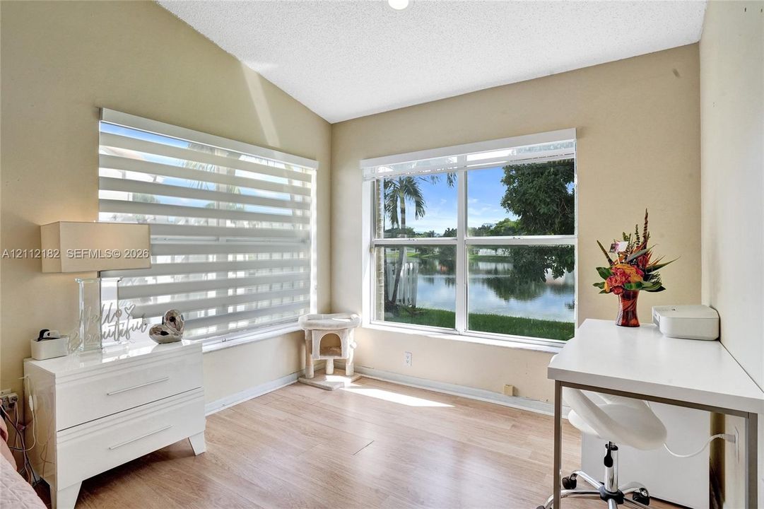 Vaulted ceiling with wood-finish flooring, dual-aspect windows, and water-facing exterior exposure