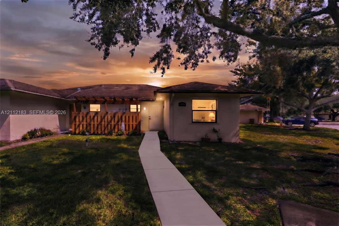 Exterior featuring a stucco facade, concrete walkway, and wood-slat privacy pergola