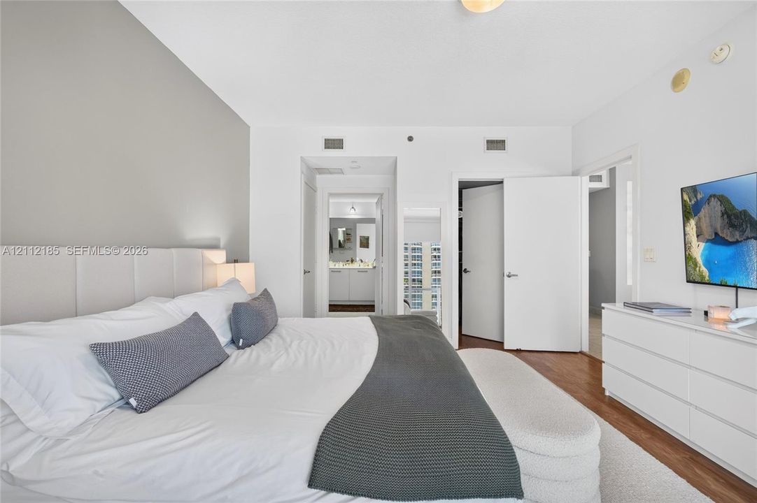 Neutral interior featuring wood-finish flooring, a charcoal gray accent wall, and solid-core interior doors