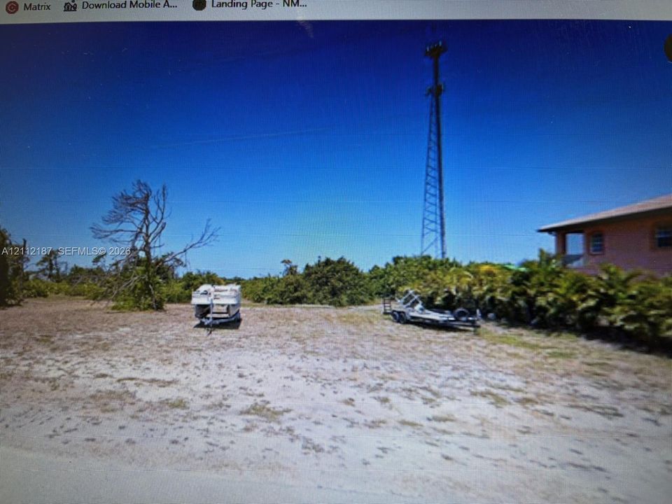Open parcel featuring sandy terrain, native vegetation, and mature trees