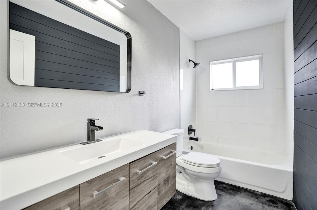 Modern vanity with a rectangular sink, quartz countertop, and matte black hardware