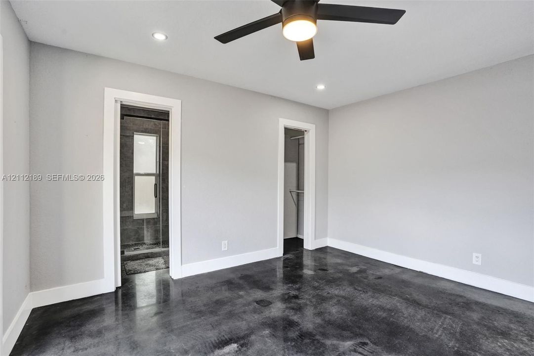 Polished concrete flooring, recessed lighting, and a modern ceiling fan with integrated lighting