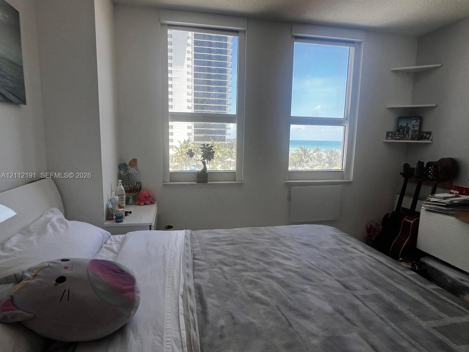 Dual vertical windows, built-in wall shelving, and water horizon backdrop