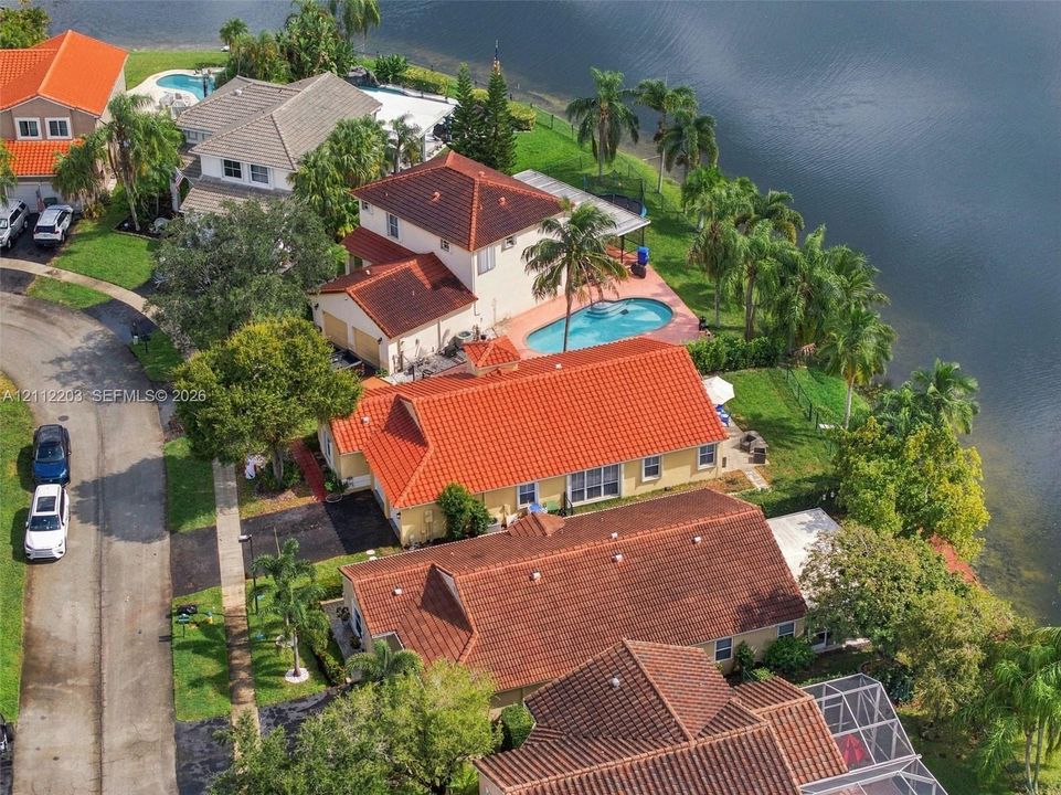 Waterfront property featuring a clay tile roof, private swimming pool, and direct canal access
