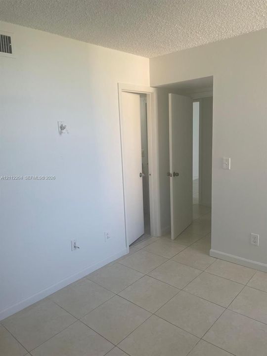 Interior room featuring neutral wall paint, tile flooring, and solid-core doors