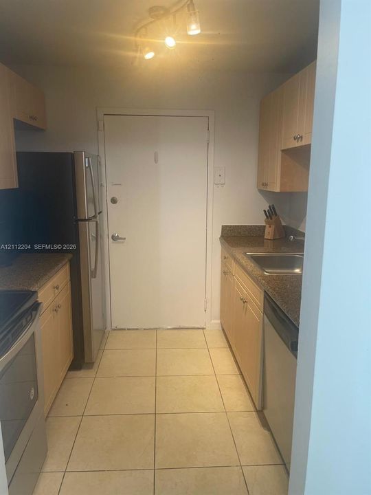 Kitchen featuring light-finish cabinetry, stone-surface countertops, tile flooring, stainless steel appliances, and multi-bulb track lighting