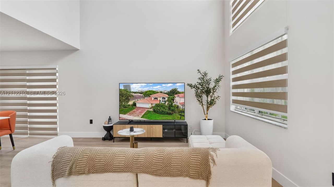 Double-height ceilings, expansive wall space, and tiered roller window shades