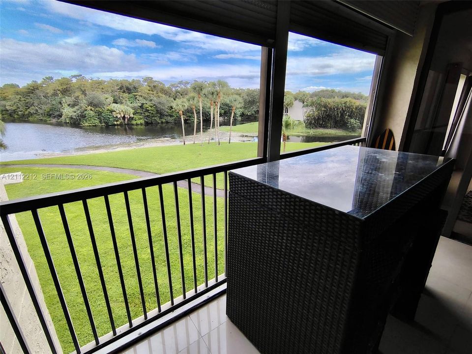 Screened balcony featuring metal railings, tiled flooring, and a sliding glass door enclosure