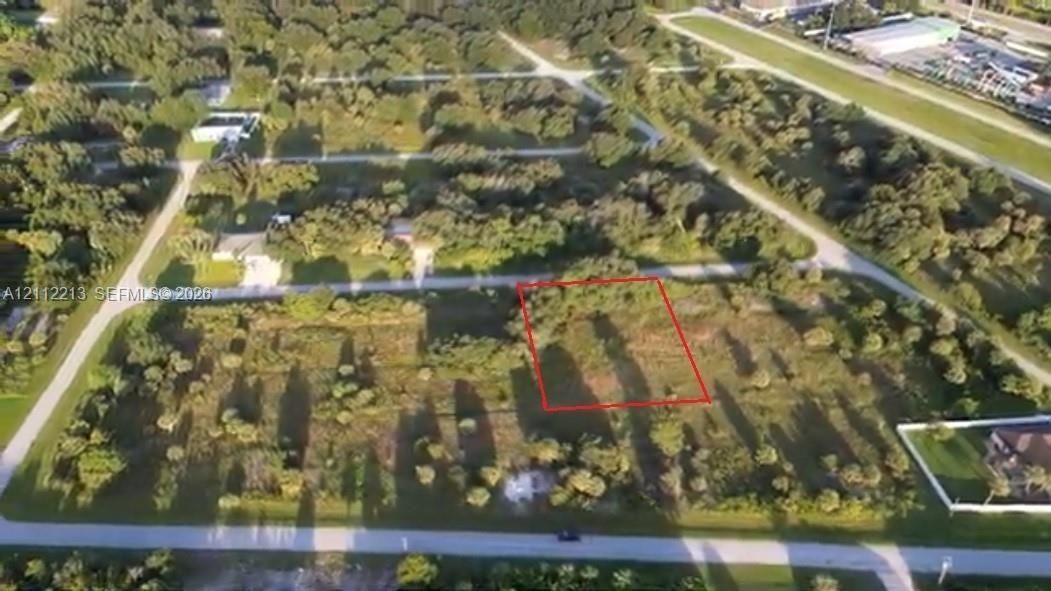 Undeveloped parcel of land featuring mature trees, native vegetation, and direct road access