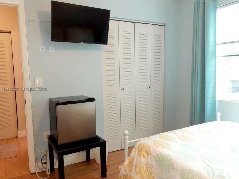 Light-toned wood-finish flooring and louvered-style bi-fold closet doors