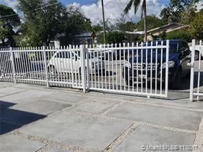 White metal picket fencing with a sliding access gate, featuring a concrete paver driveway with gravel fill