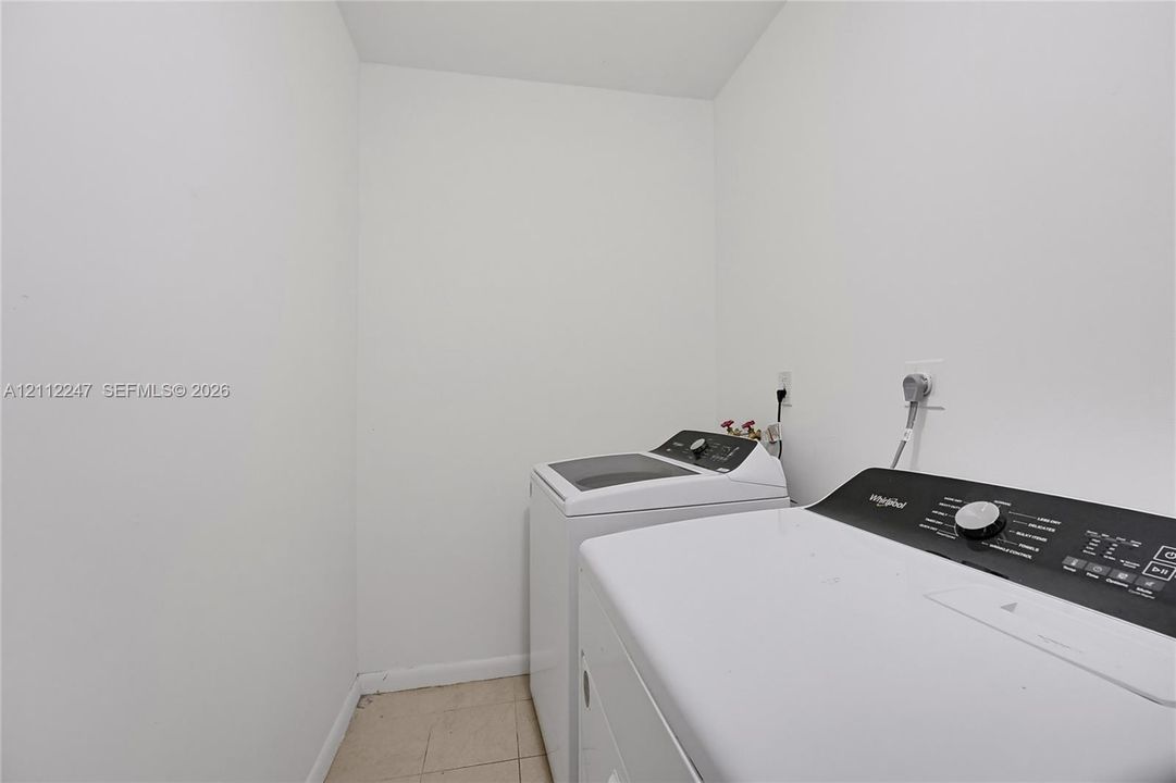 Laundry area featuring white walls, tile flooring, and dedicated electrical and plumbing connections for appliances