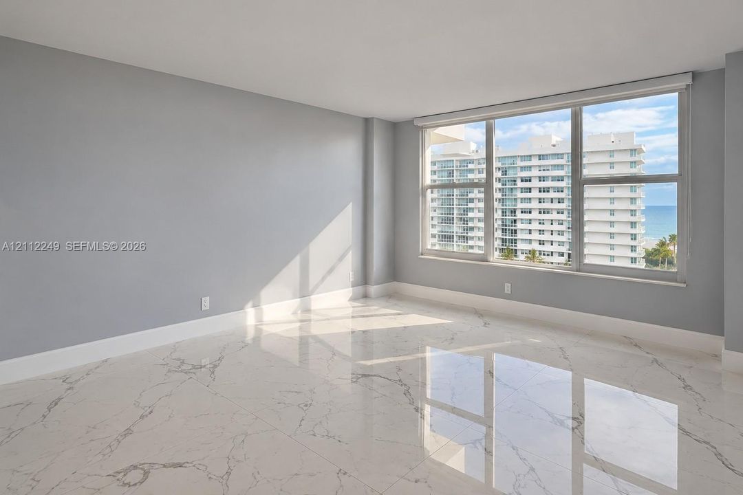 Large-format polished stone flooring with veining detail, expansive windows, and neutral interior paint palette