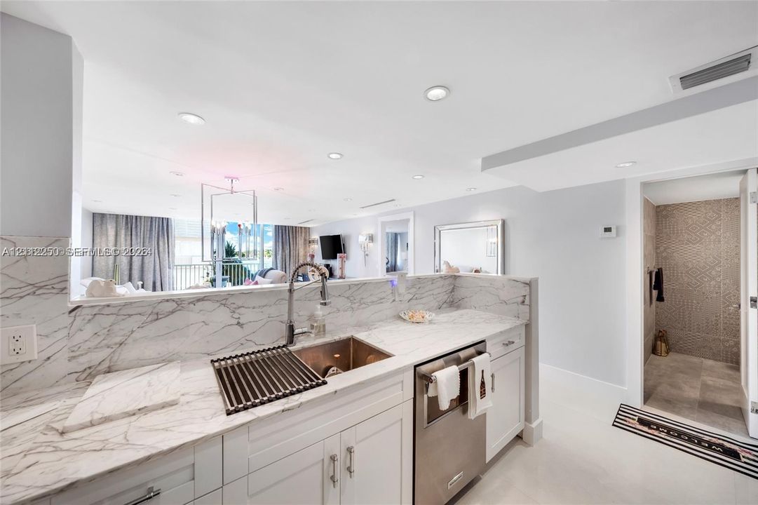 Kitchen featuring stone-patterned countertops, white cabinetry, a stainless steel undermount sink with a gooseneck faucet, and recessed lighting