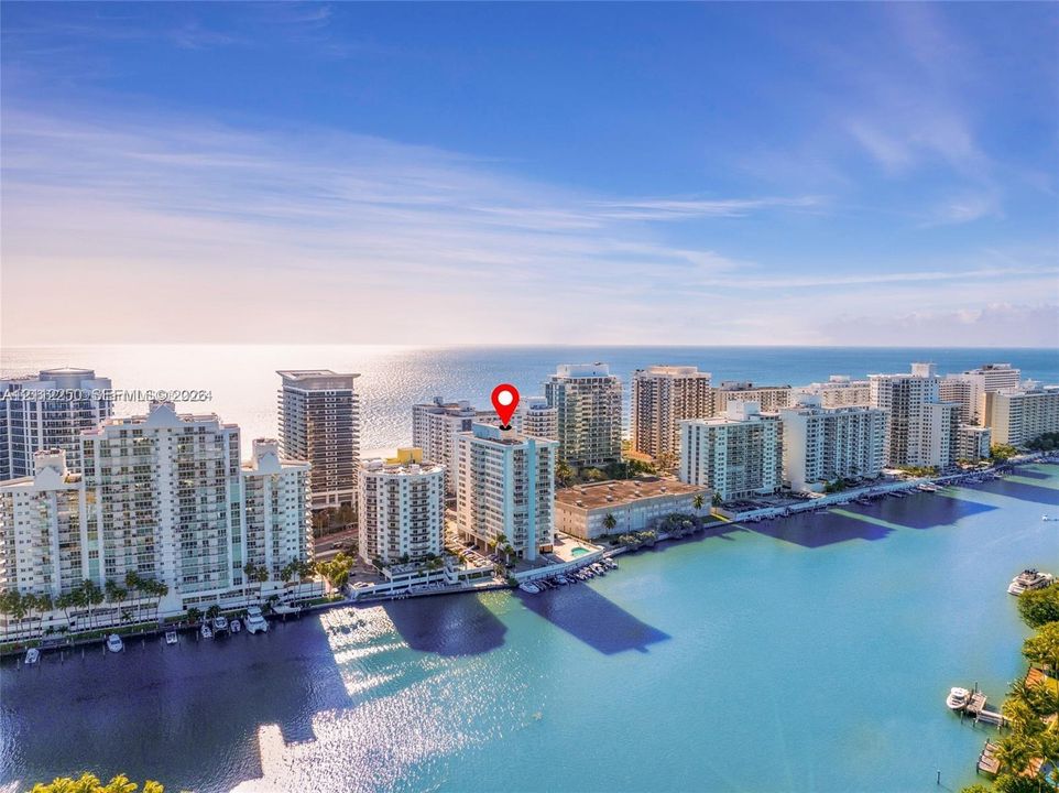 High-rise residential building featuring expansive water frontage, deep-water canal access, and immediate proximity to the coastline