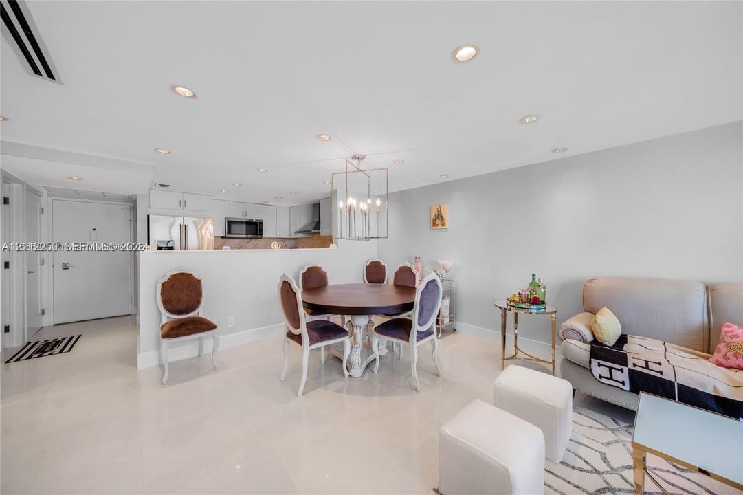 Open concept interior featuring polished stone flooring, recessed lighting, and a geometric multi-light metal pendant fixture