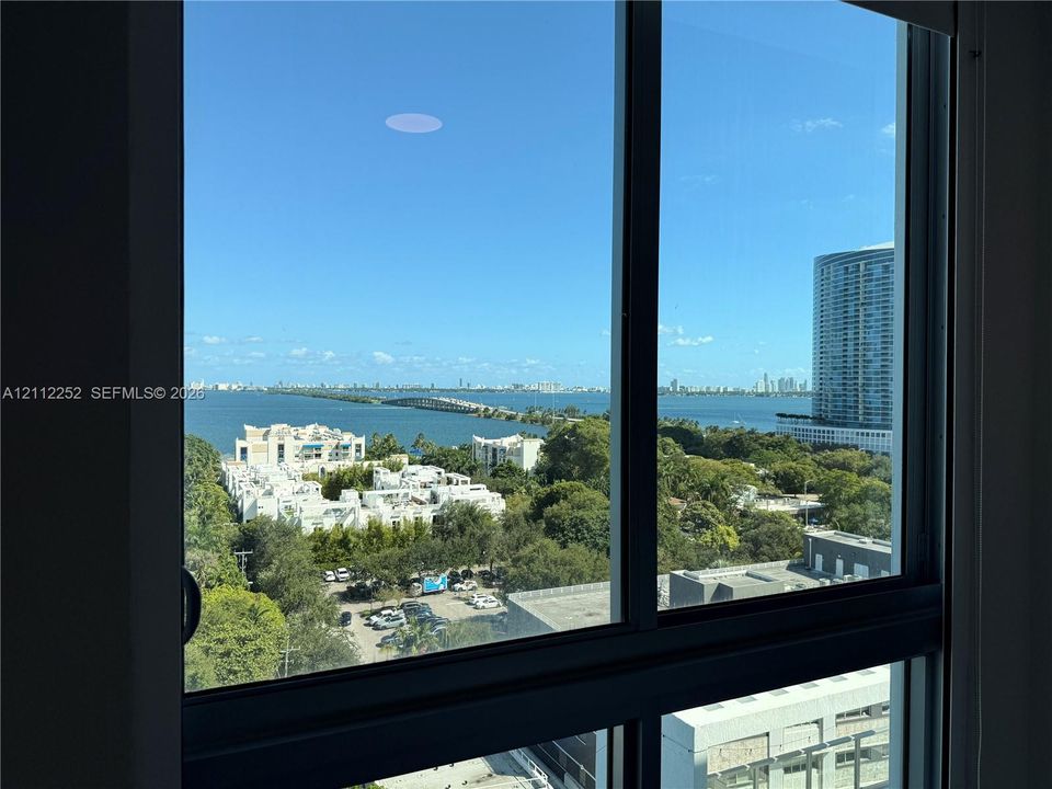 Floor-to-ceiling windows with expansive water and metropolitan skyline backdrop