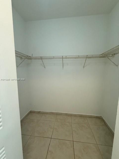 Walk-in storage space featuring ceramic tile flooring and integrated wire shelving