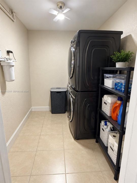 Dedicated laundry area featuring ceramic tile flooring, neutral wall tones, and a ceiling-mounted light fixture
