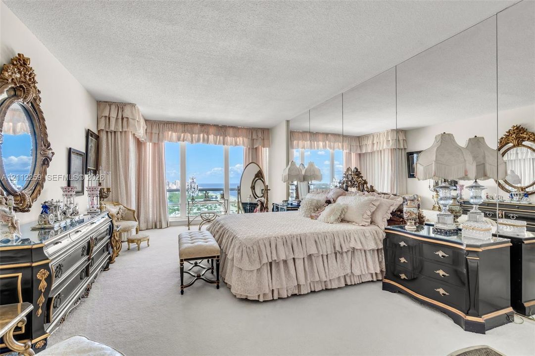 Floor-to-ceiling windows, full-wall mirrored accent, and wall-to-wall carpeting