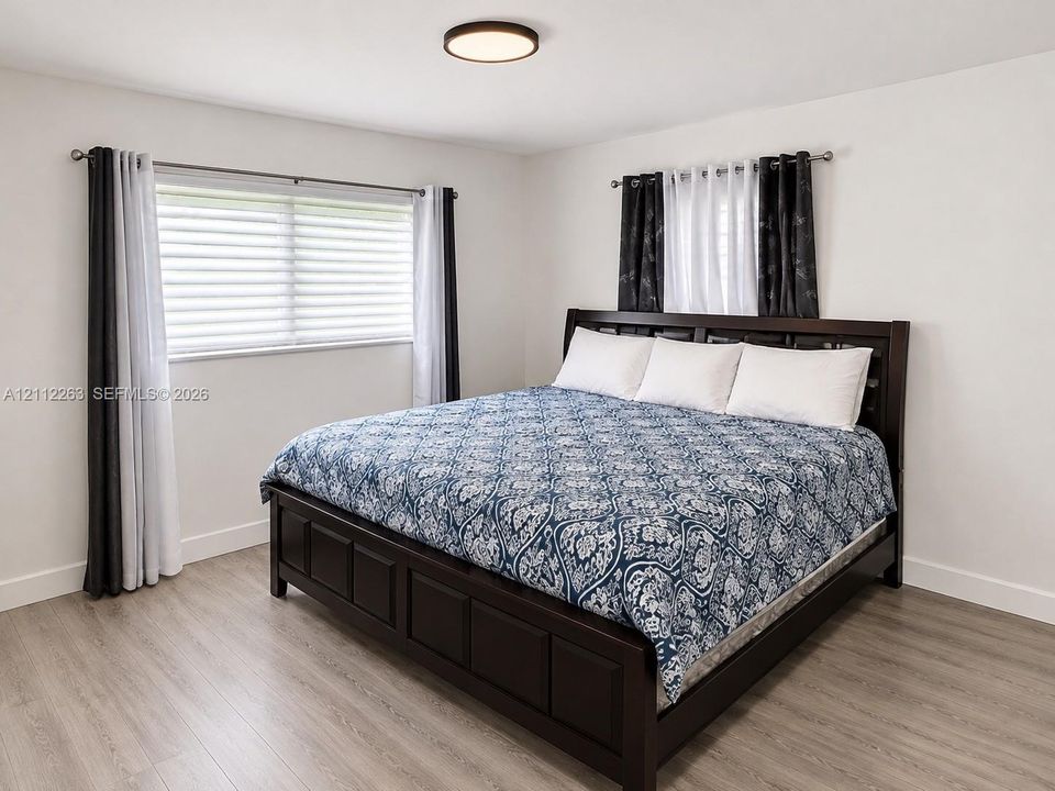 Room featuring wood-finish flooring, neutral wall paint, and a low-profile flush-mount ceiling light fixture
