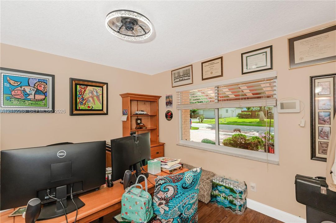 Room featuring a circular LED-integrated ceiling fixture, wood-finish flooring, and a large horizontal window with neutral blinds