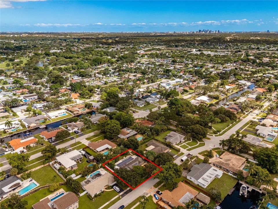 Aerial perspective featuring a residential lot with solar panel installation and established trees