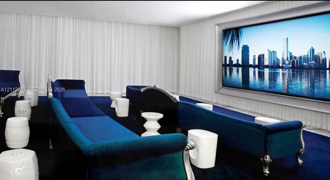 Media room featuring a wall-mounted display, recessed ceiling lighting, wall-to-wall carpeting, and full-height floor-to-ceiling drapery