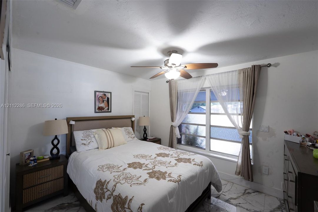 Large-format tile flooring, multi-pane window, and integrated ceiling fan with light fixture