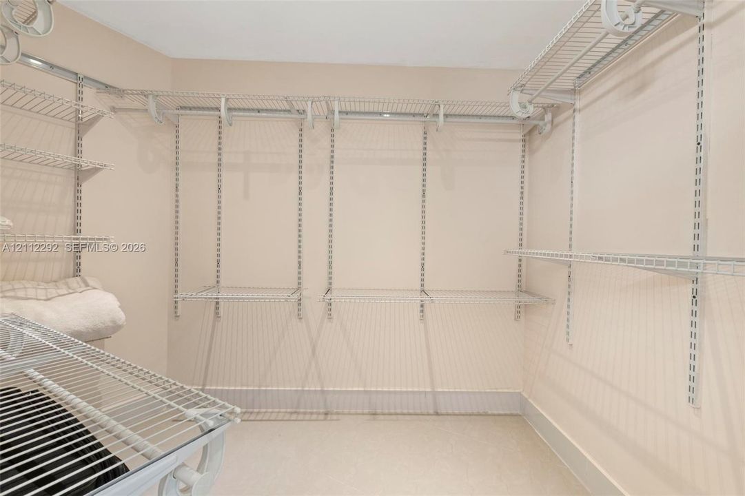 Walk-in closet featuring adjustable wire shelving and a vertical track mounting system