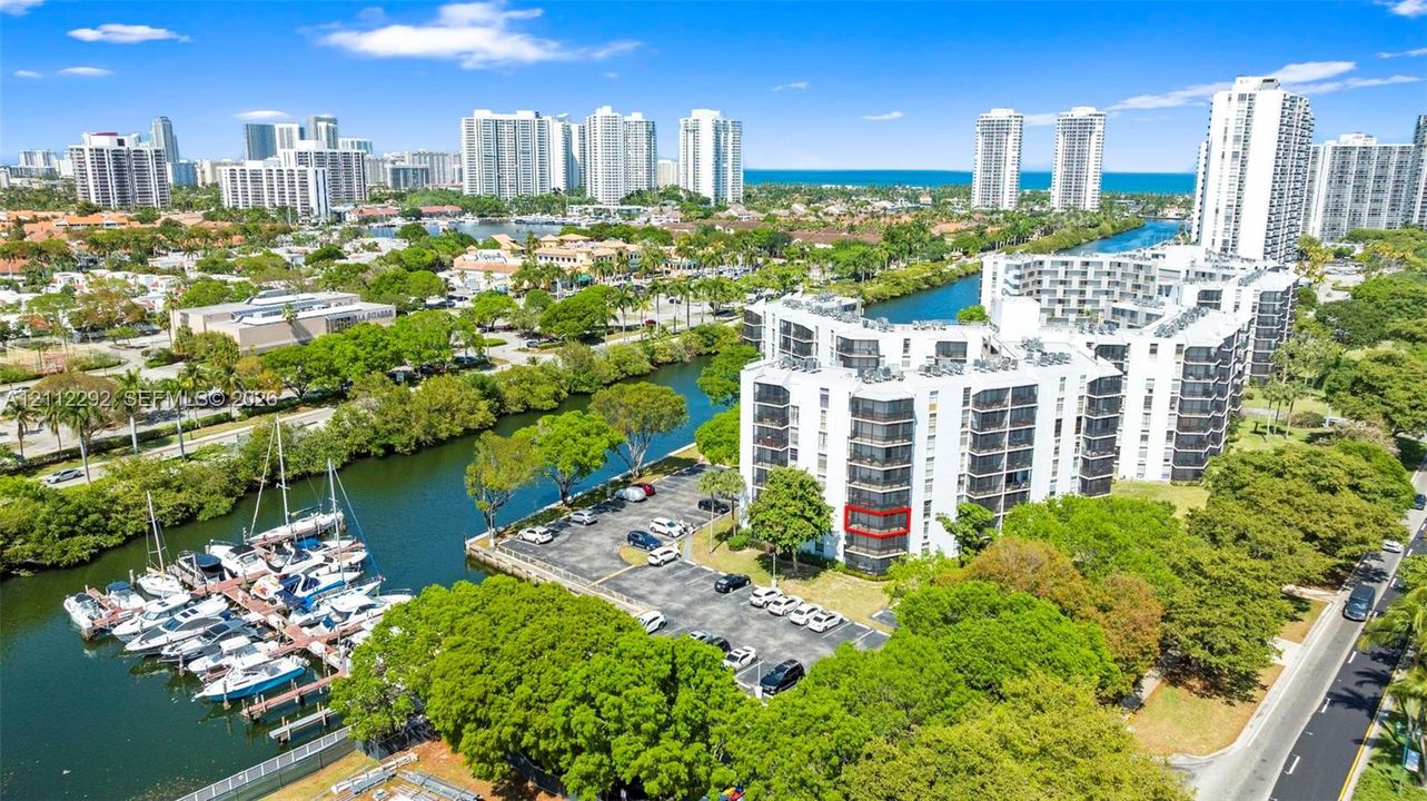 Multi-story residential building featuring private balconies, surface parking, and waterfront bulkhead infrastructure with direct water access