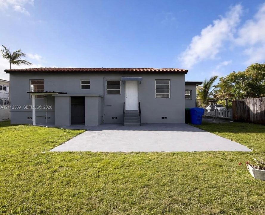 Exterior elevation featuring a concrete patio, tile roof, and horizontal sliding windows