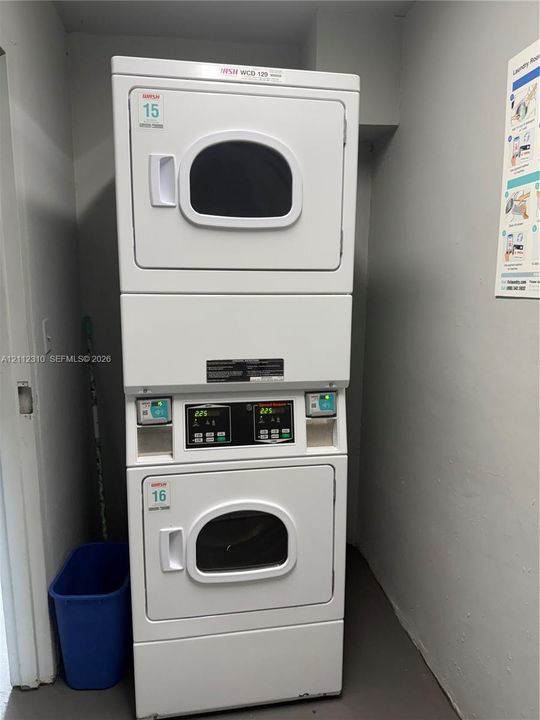 Stacked, commercial-grade clothes drying unit featuring digital interface panels and coin-operated mechanisms