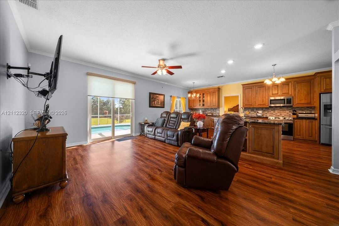 Open concept floor plan featuring wood-finish flooring, recessed lighting, ceiling fan, and sliding glass doors with direct exterior access