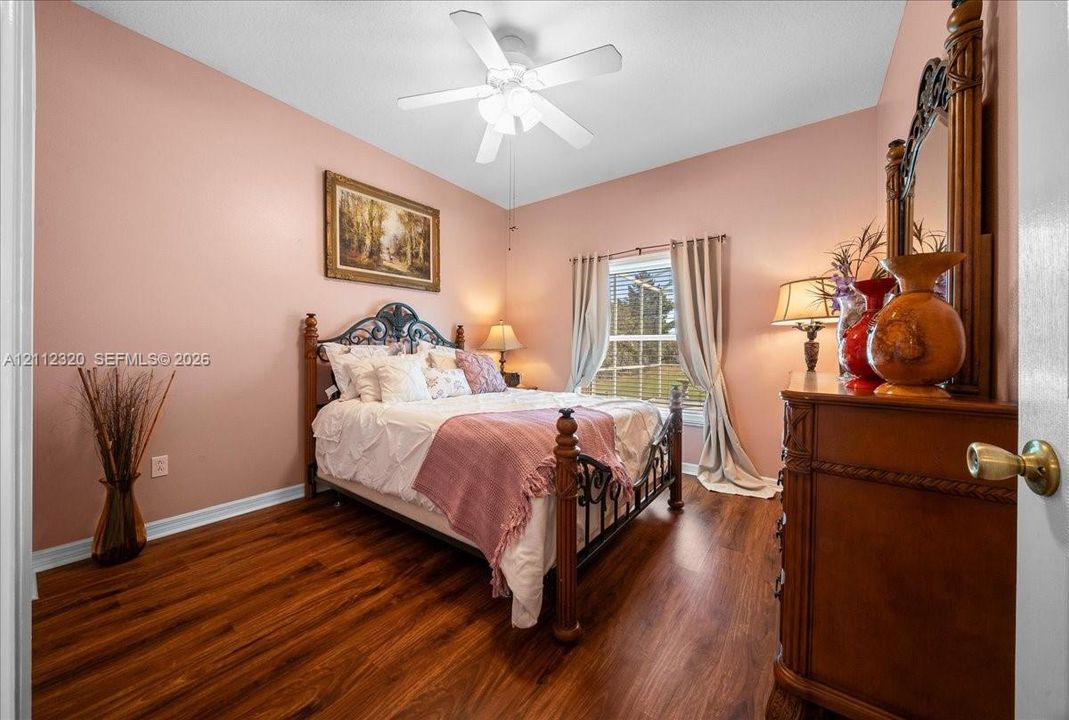Wood-finish flooring, multi-pane window, and central ceiling fan with integrated lighting